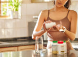 Junge Frau nimmt Vitamine für Schwangerschaft