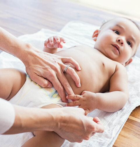 Mutter wickelt Baby nach Stuhlgang auf Tisch