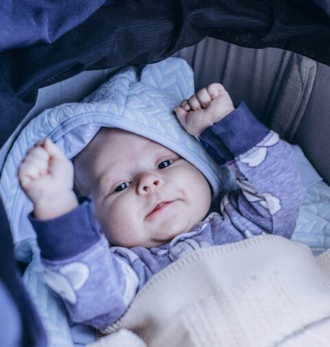 Baby in Schale mit Fußsack