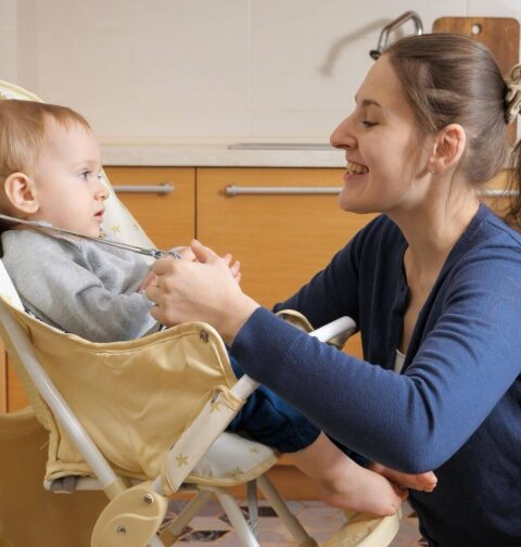 Baby im Hochstuhl mit Mutter