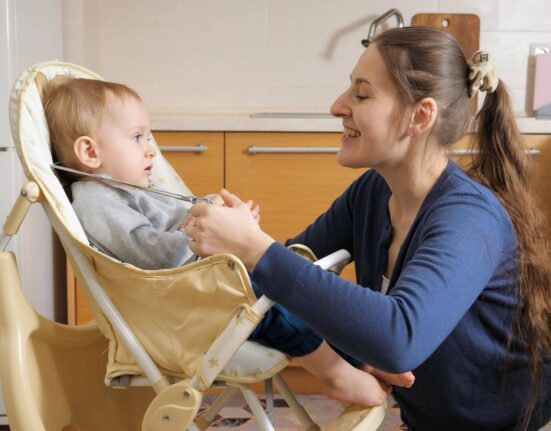Baby im Hochstuhl mit Mutter