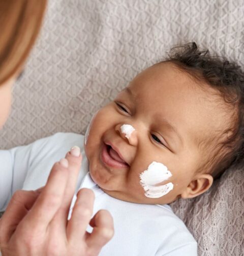 Baby mit Creme im Gesicht