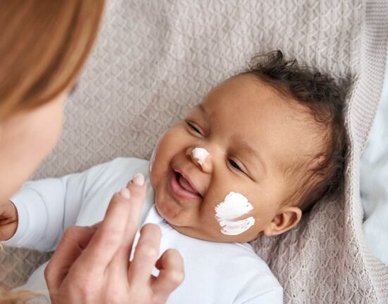 Baby mit Creme im Gesicht