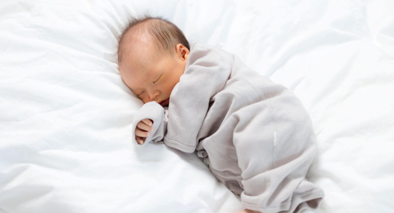Baby schläft auf weißer Decke