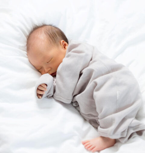 Baby schläft auf weißer Decke