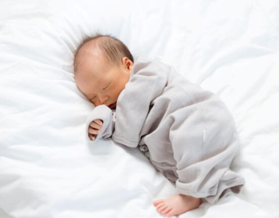 Baby schläft auf weißer Decke