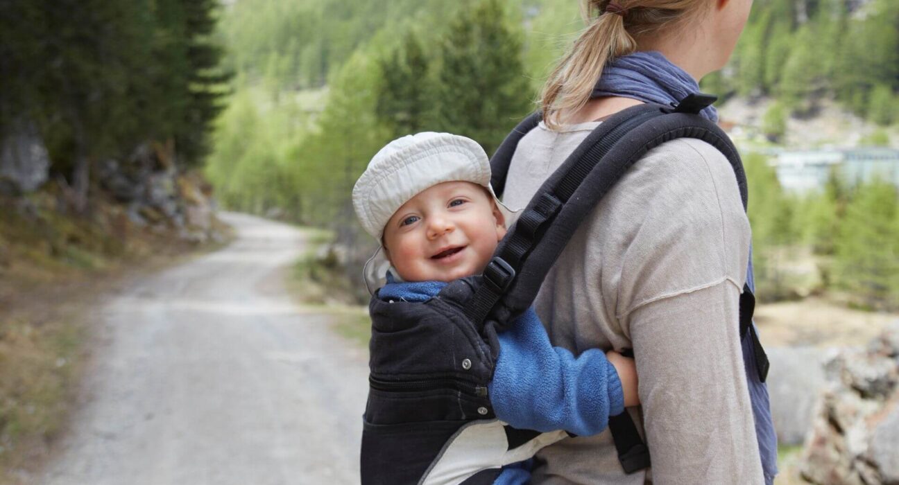 Mutter trägt Baby auf dem Rücken