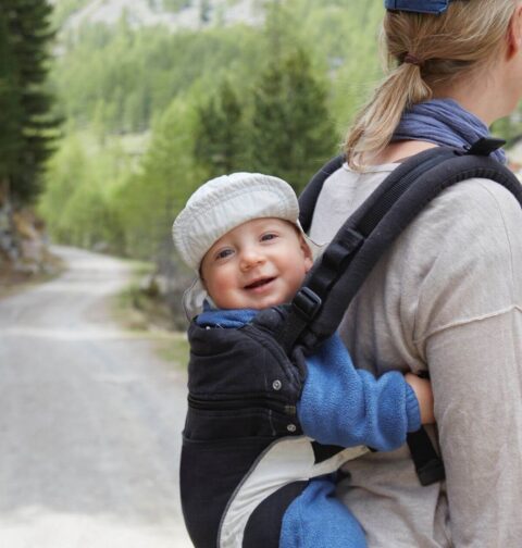 Mutter trägt Baby auf dem Rücken