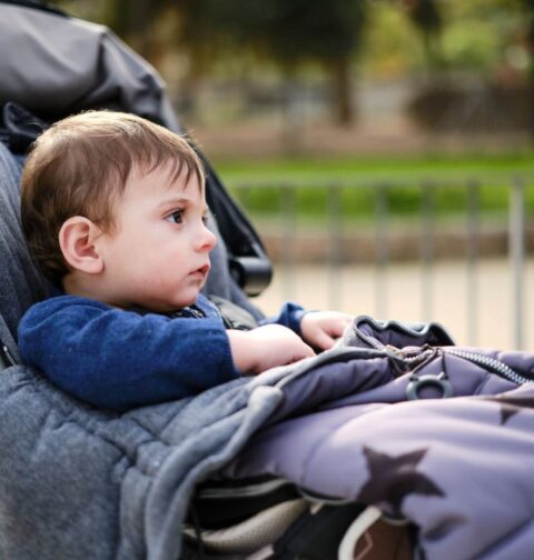 Junge halbsitzend im Kinderwagen