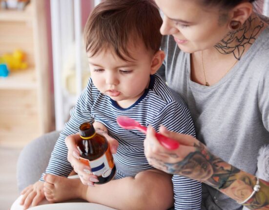 Mutter gibt Kleinkind Hustensaft