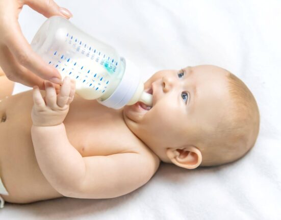 Baby trinkt aus Babyflasche