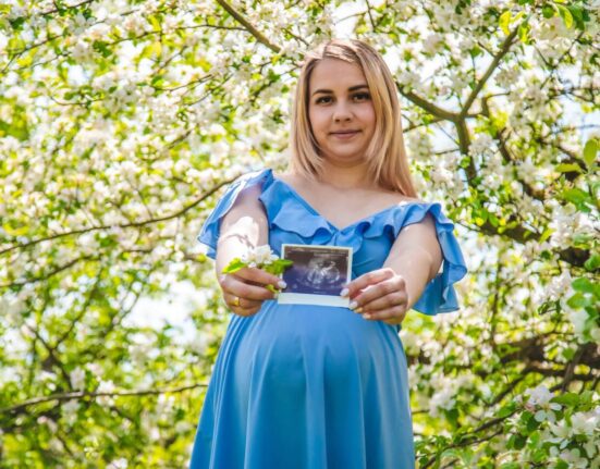 Schwangere Frau hält ihr Babyfoto