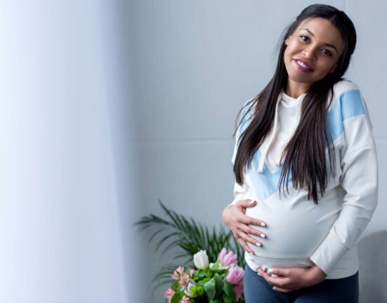 Schwangere Frau hält ihren Bauch