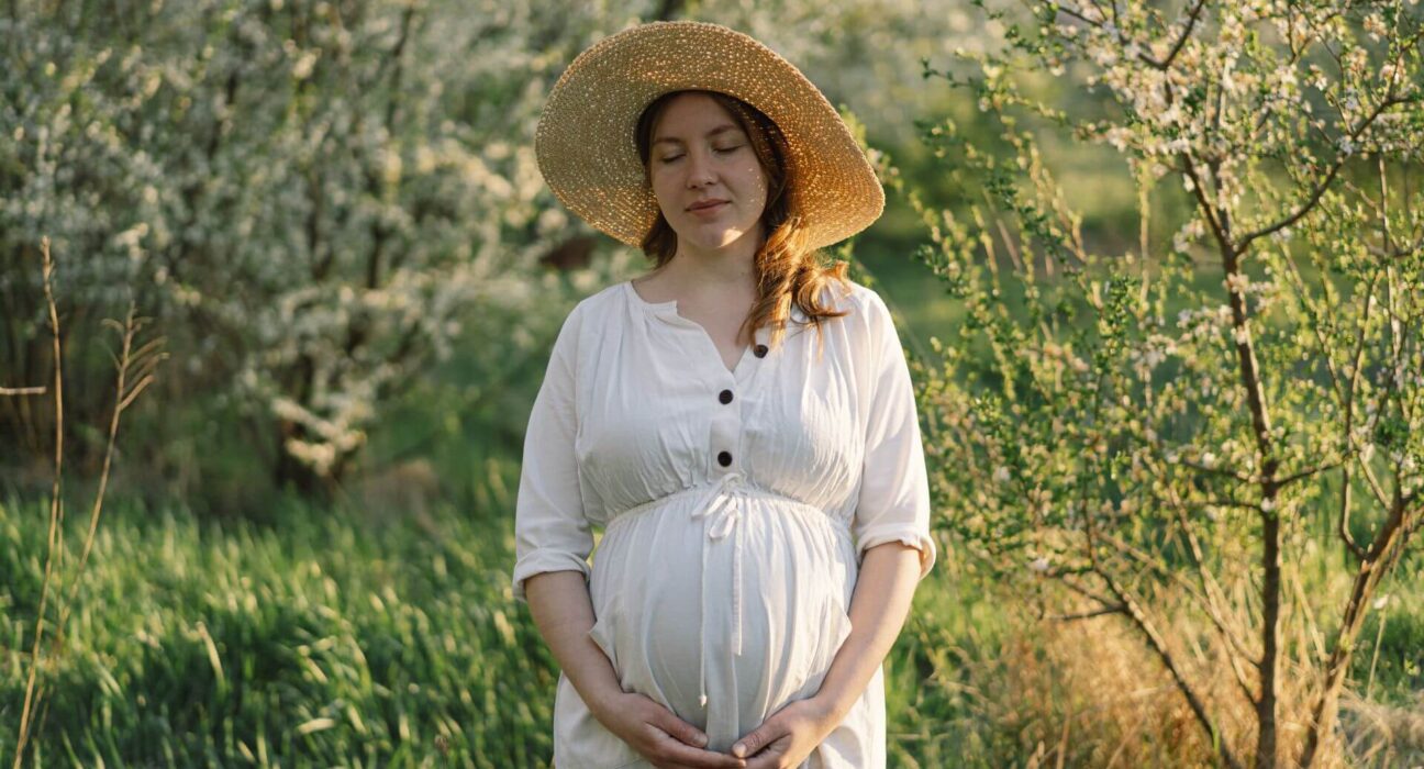 Schwangere Frau draußen im Frühling