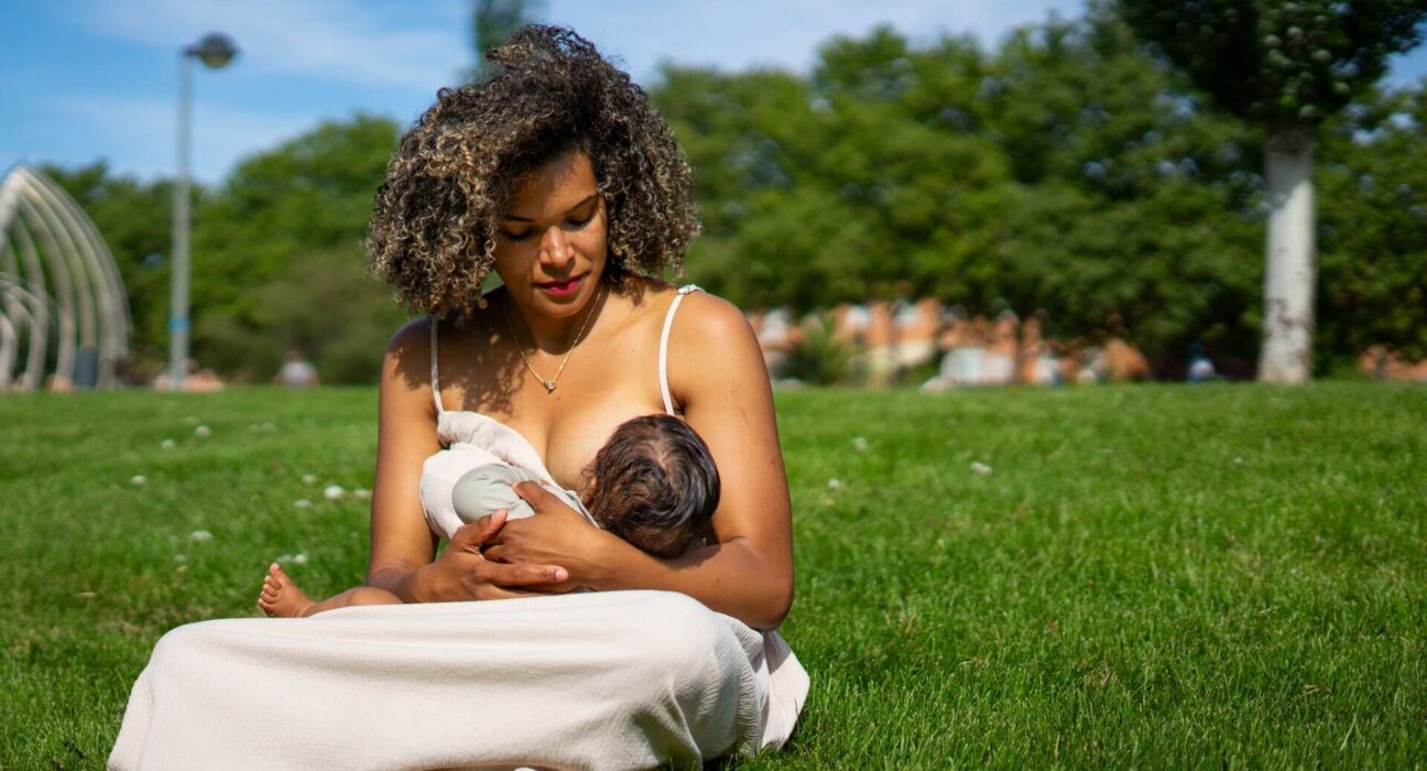 Mutter stillt ihr Baby auf einer Wiese