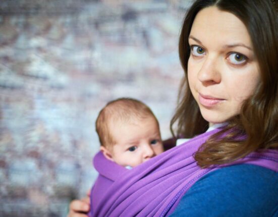 Mutter und ihr Baby im Tragetuch