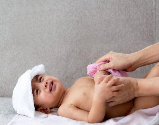 Baby wird mit Waschlappen gewaschen